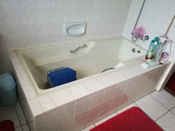 Plumber working on clearing blocked bath drain
