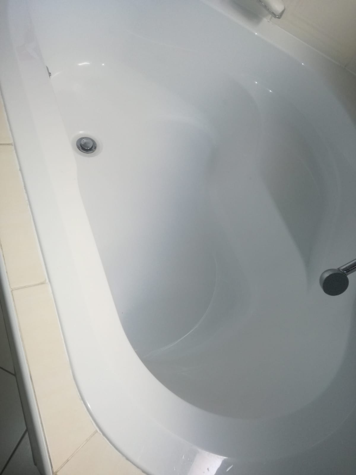 Clean white bathtub in Linden after leaking bath repair, showing bath drain and overflow fittings with no visible water leaks or damage following plumbing maintenance.