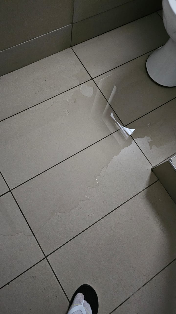 Leaking toilet waste pipe repaired in Blairgowrie, showing water on bathroom floor near toilet after leak from waste pipe before repair and restoration of proper drainage.