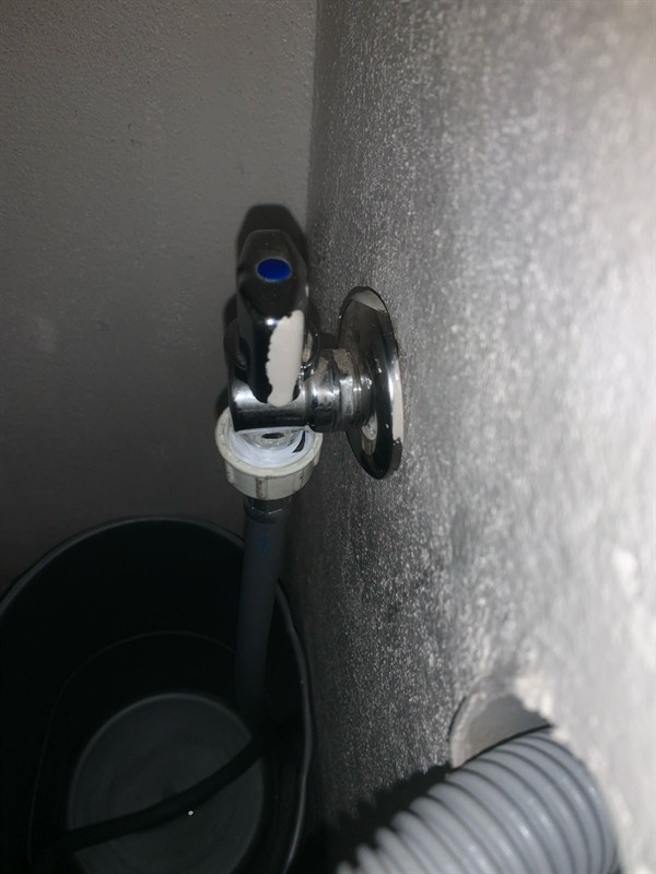 Leaking stop valve at washing machine connection with water accumulation