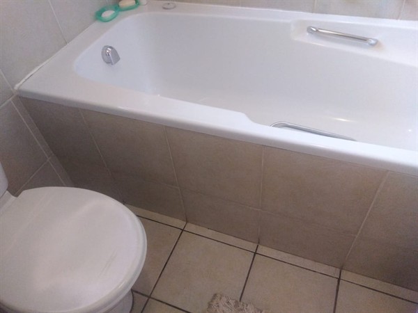 Technician fixing blocked bath drain