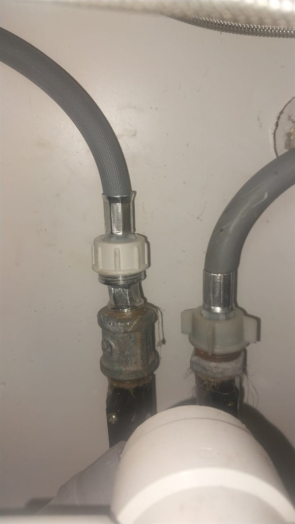 Angle valve being removed from washing machine supply line