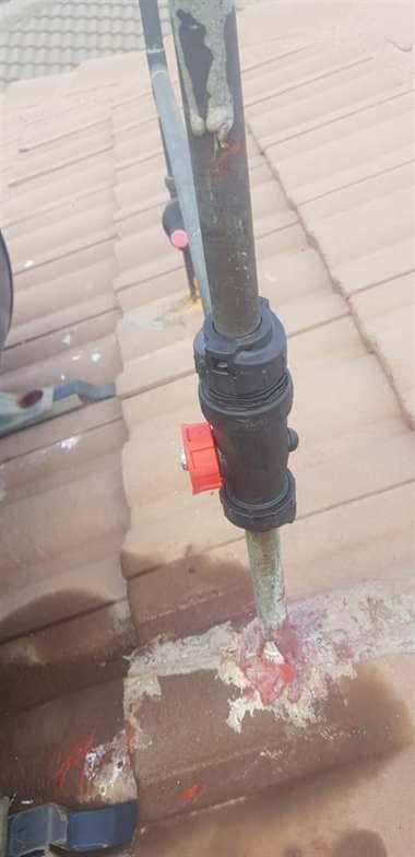This image shows a rooftop plumbing pipe with a visible joint connection and a shut-off valve. Around the base of the pipe, there are clear water stains and mineral deposits seeping into the roof tiles, strong indicators of a leaking pipe. The discoloration and moisture marks highlight one of the classic signs of a hidden leak — water escaping slowly and leaving traces of dampness and corrosion. While the issue may look small, it can lead to bigger problems like structural roof damage, mold growth, and wasted water if not repaired promptly. The picture emphasizes the importance of noticing early warning signs of leaks before they escalate into costly repairs.